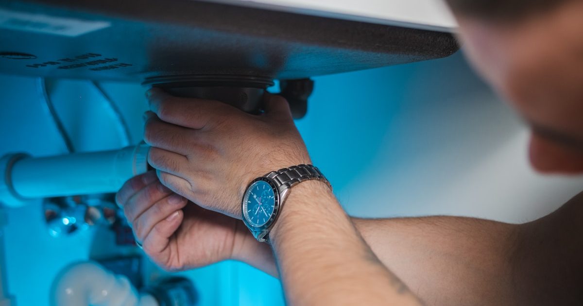 Plumber working under a sink